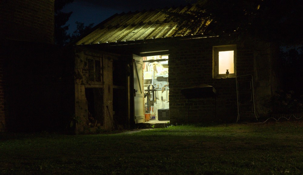 Photographie d'un atelier éclairé de l'intérieur, la nuit
